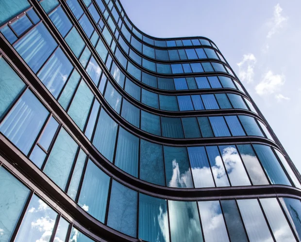 High Rise Building Glass Facade With Reflection Surrounding Buildings 1